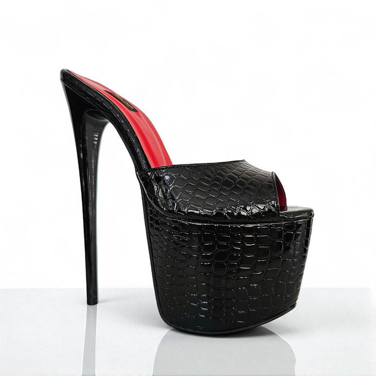 Black high-heeled shoe with red interior on a white background