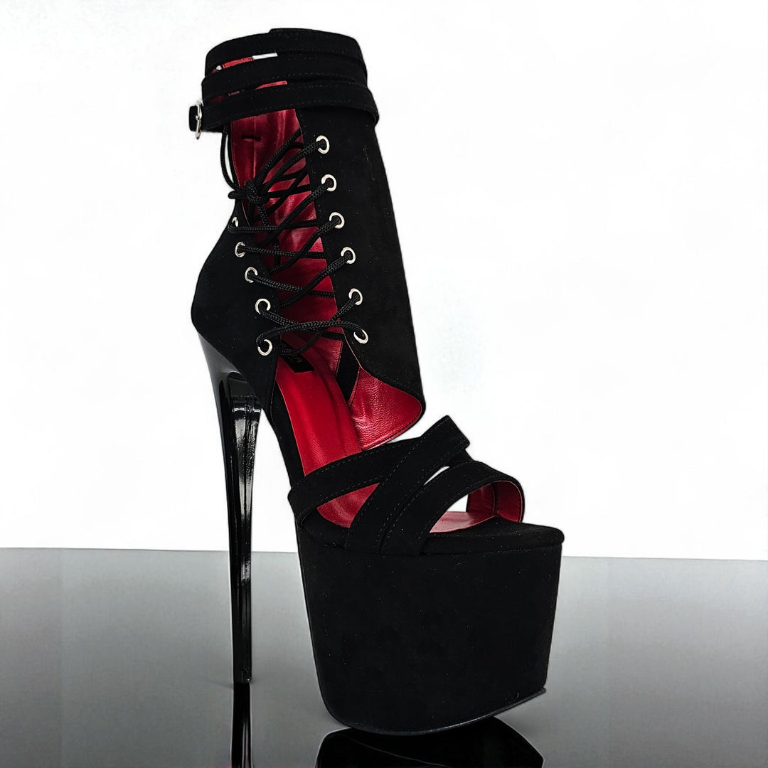 Black high-heeled platform shoe with red interior on a white background