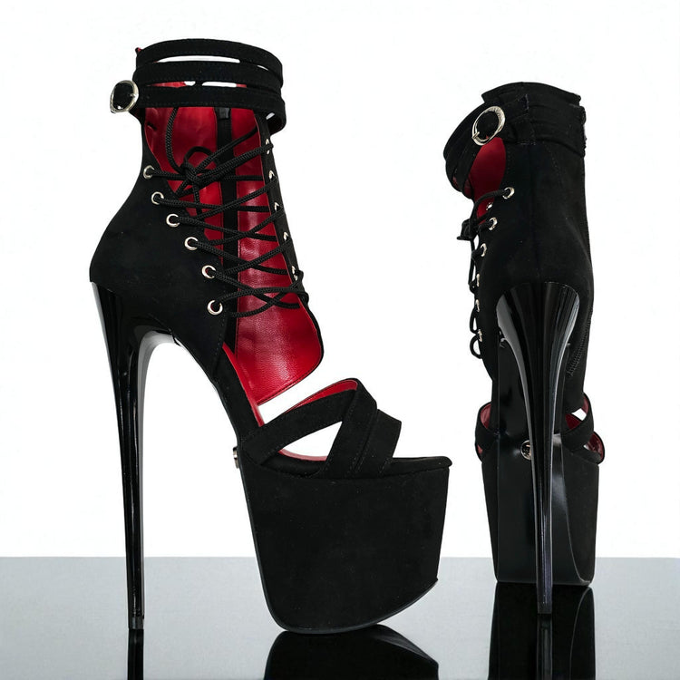 Black and red high-heeled platform boots on a reflective surface with a white background