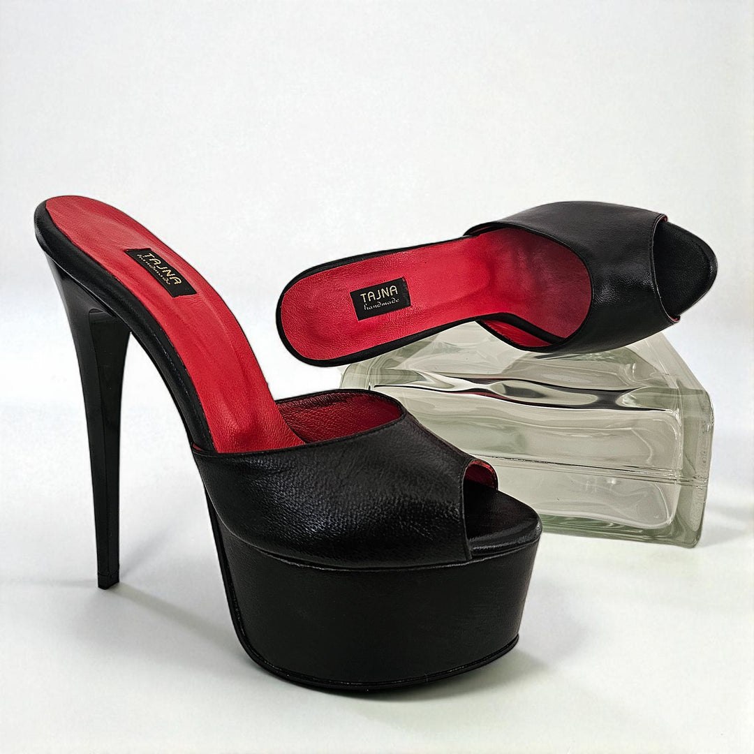 Black high-heeled platform shoes with red insoles on a white background