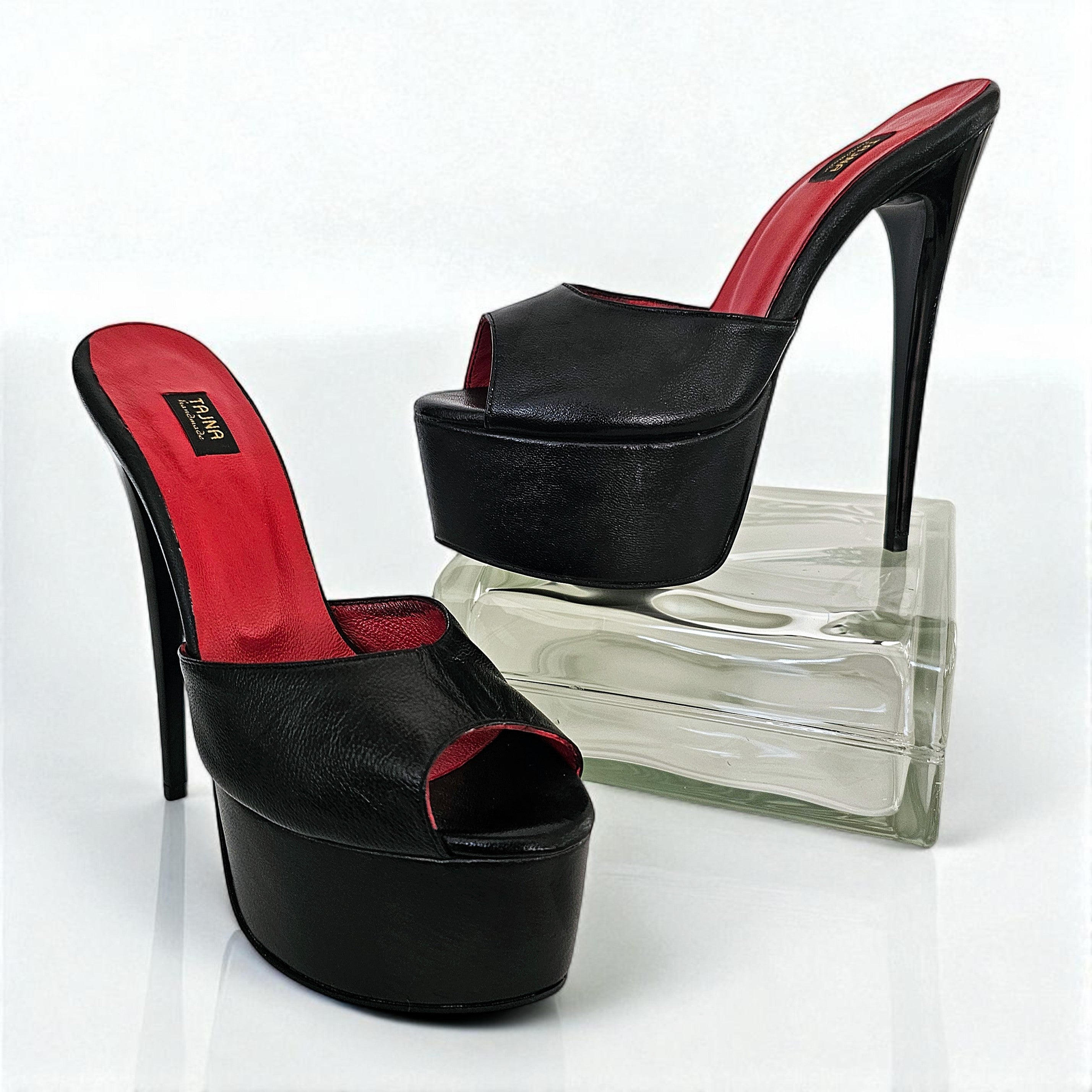 Black high-heeled shoes with red interior on a white background