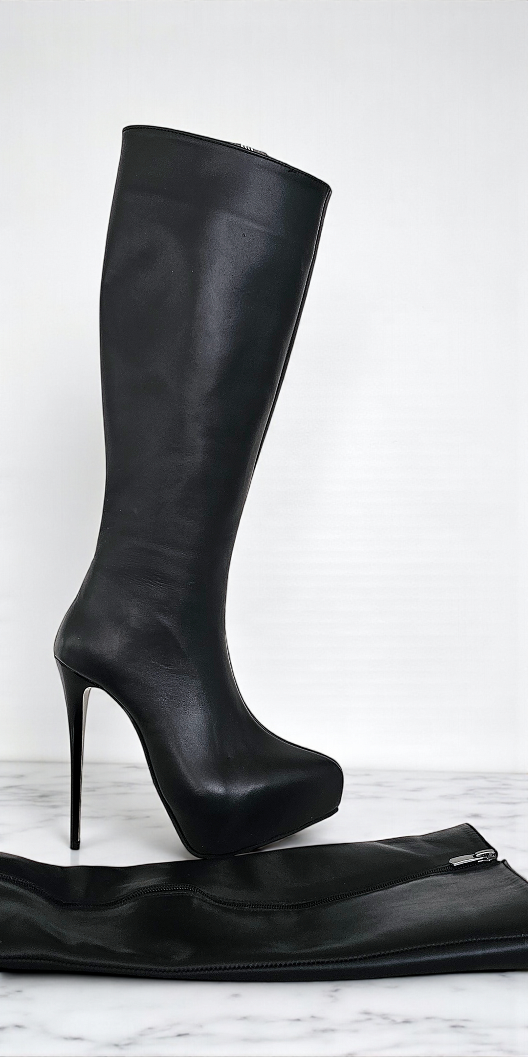Black knee-high boots with high heels on a white background