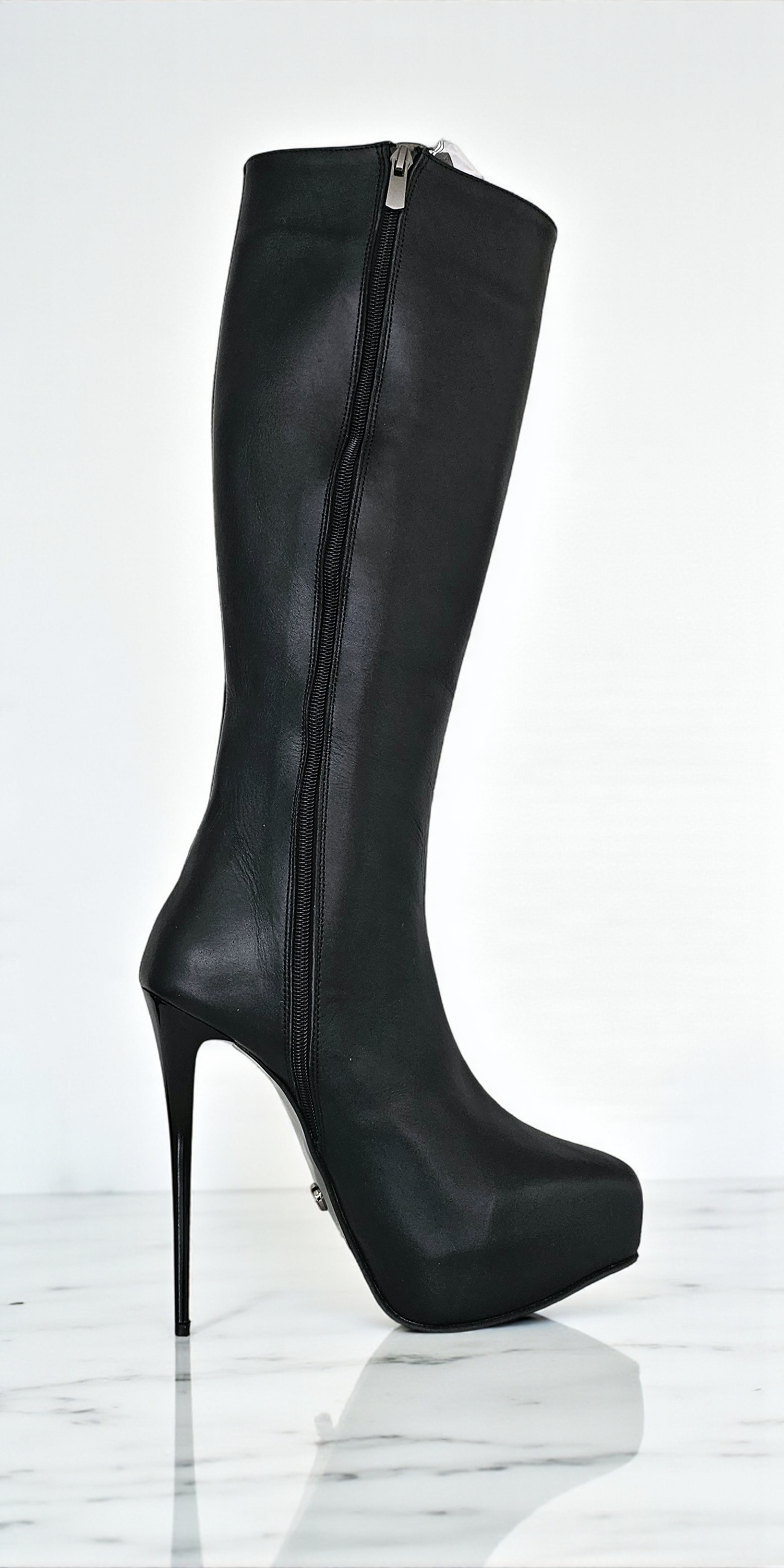 Black knee-high boot with high heel on a white background