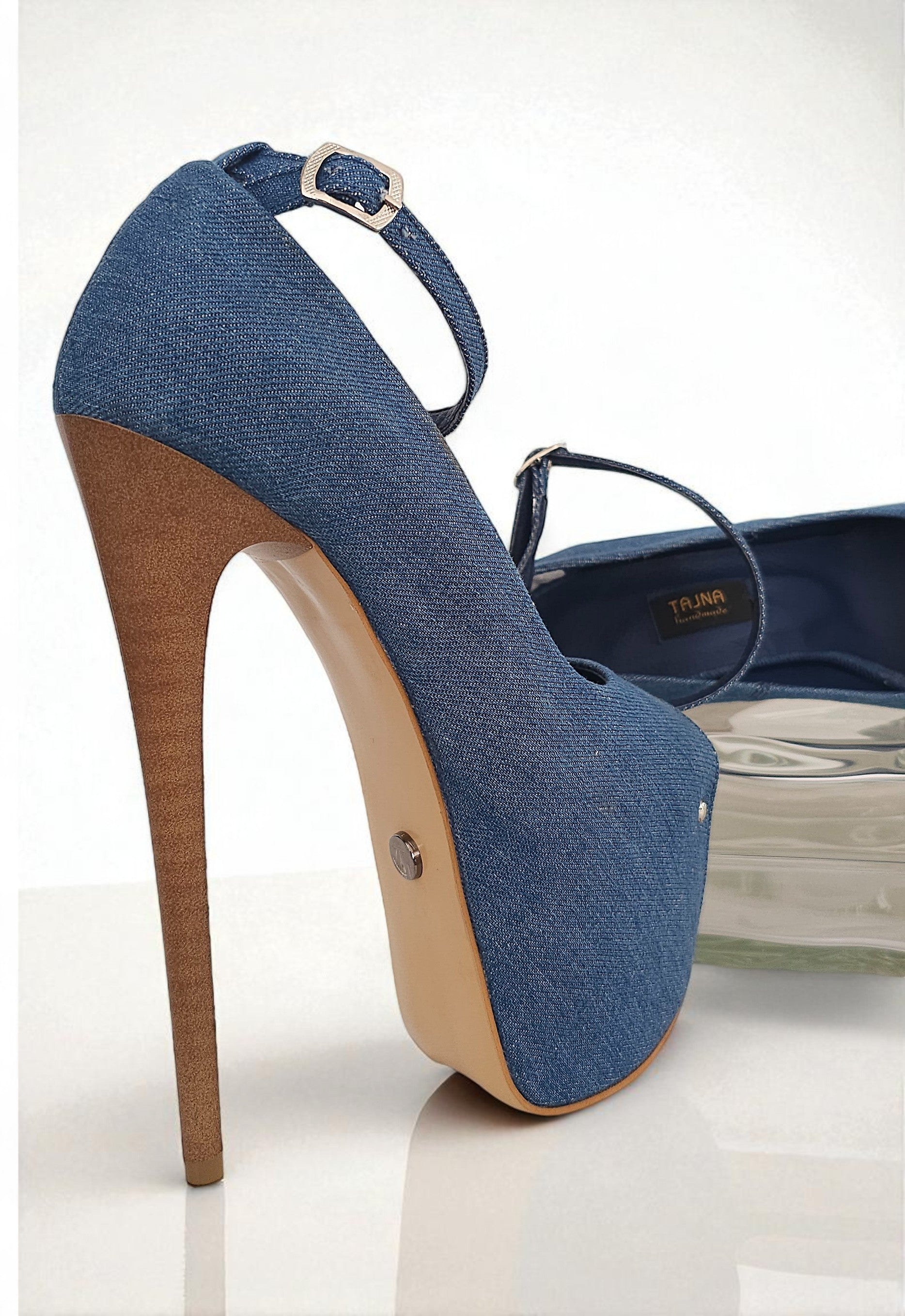 Blue denim high-heeled shoe with a brown sole on a white background