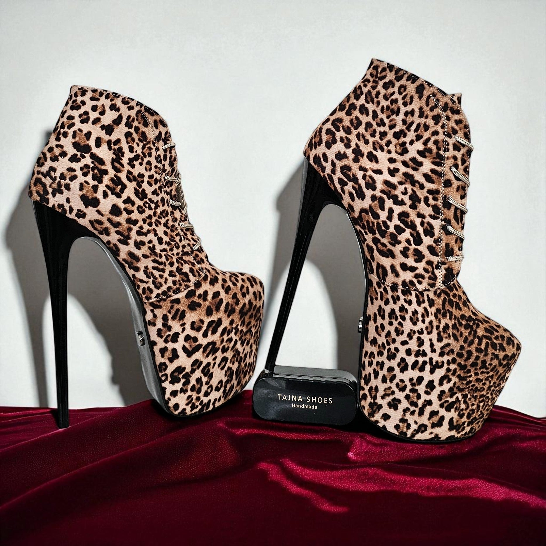 Leopard print high-heeled shoes on a red surface with a white background