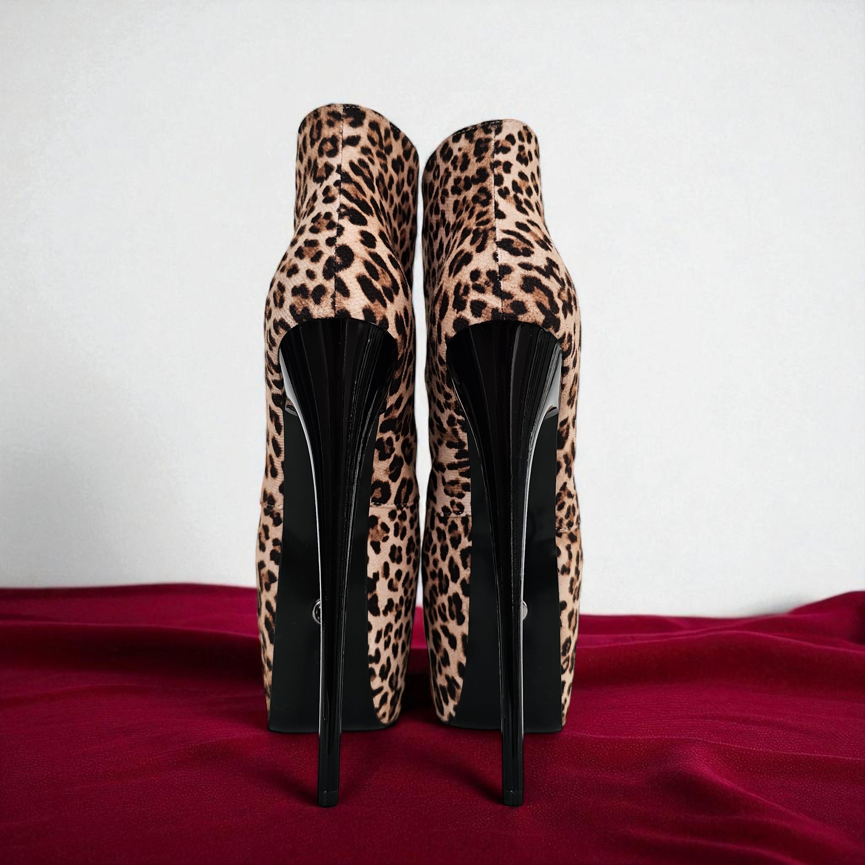 Leopard print high-heeled shoes on a red surface with a white background