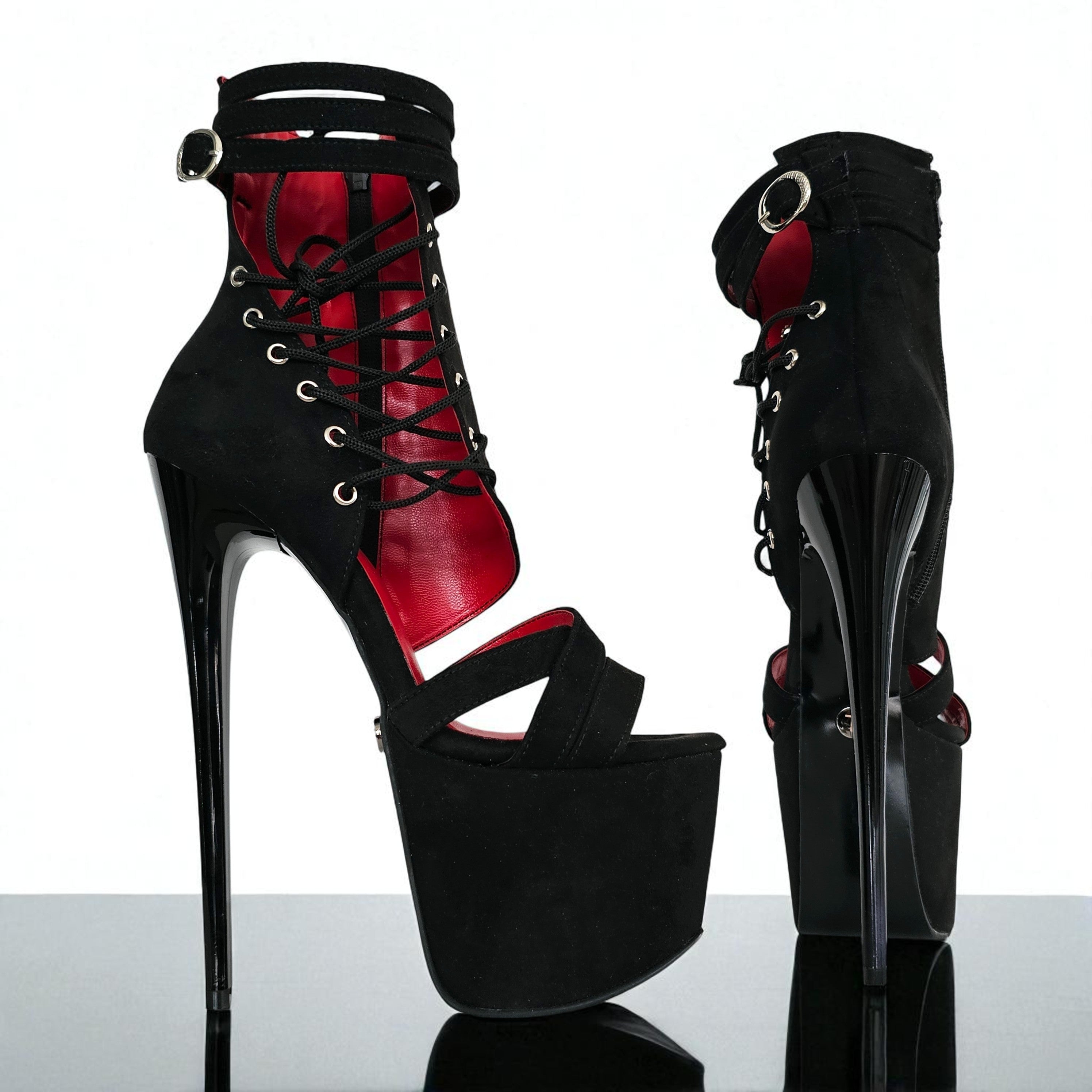 Black and red high-heeled platform boots on a reflective surface with a white background